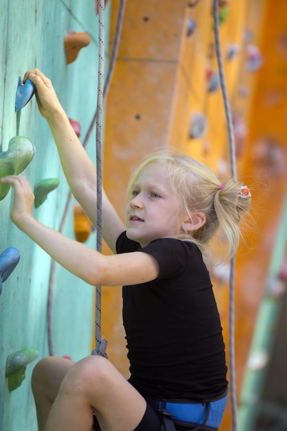 Young climber working up an indoor climbing wall